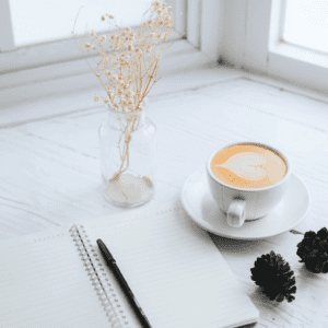 A cup of coffee and a journal, illustraing self-care