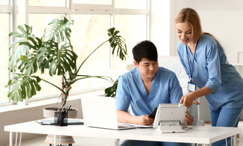 Two healthcare workers in a bright office