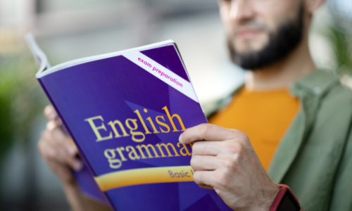 A man reading an English Grammar textbook