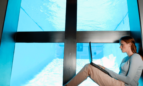 Woman on a laptop sitting infront of the Windows Logo